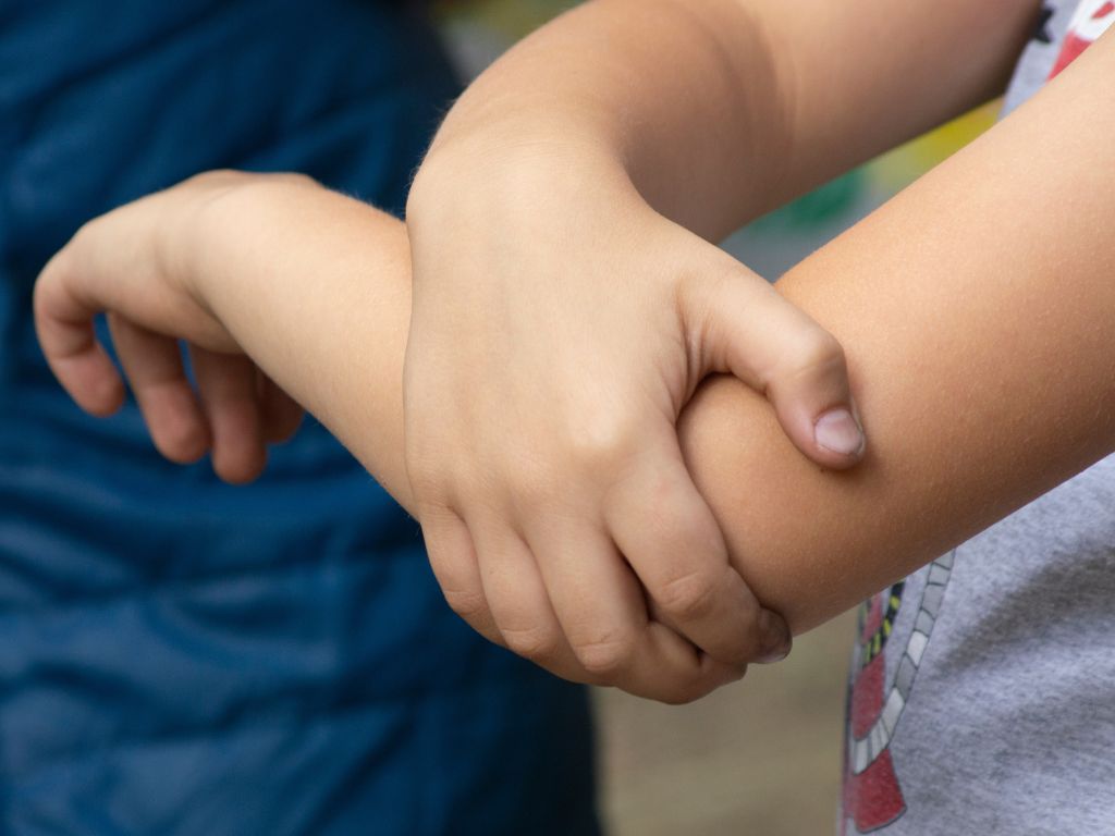 A POBAR pediatric orthopedic specialist gently guiding a child with joint concerns through safe activity, focusing on Osteochondritis Dissecans care in Brandon.