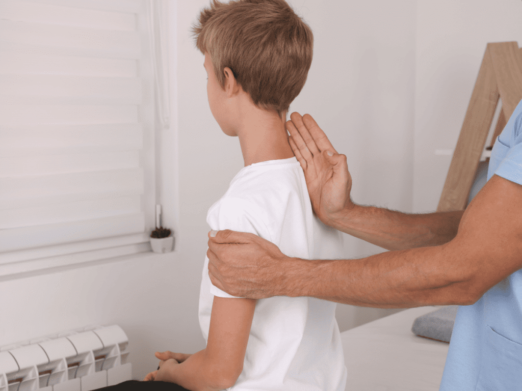 A caring pediatric specialist from POBAR observing a child’s posture to spot scoliosis early in Brandon & Riverview.