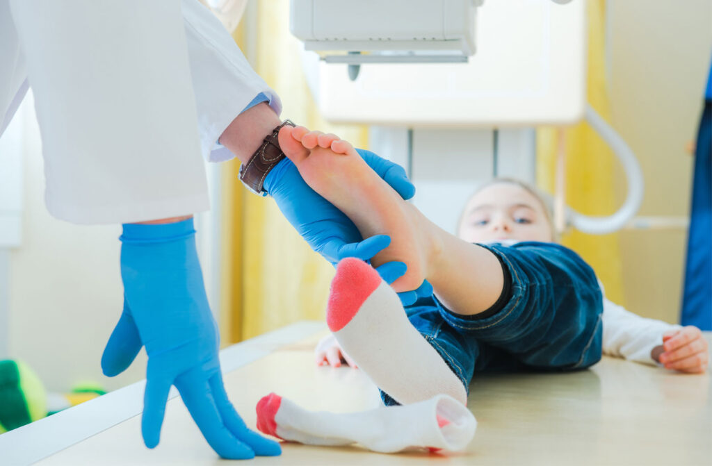 Pediatric orthopedic specialist at POBAR in Tampa, FL examining a child's growth plate injury and explaining treatment options to a concerned parent.