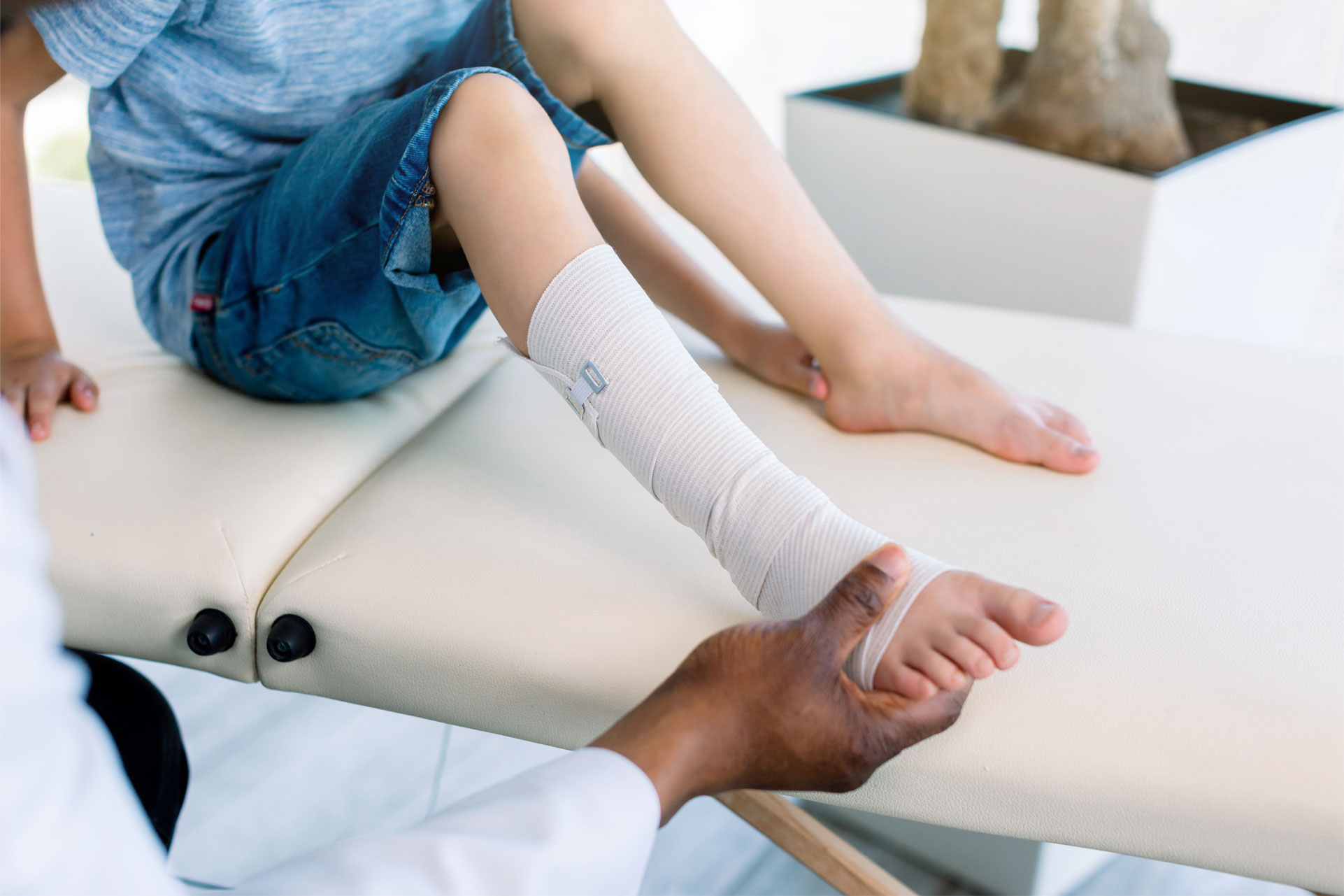 Child being evaluated for an ankle sprain at POBAR in Tampa, FL, where pediatric orthopedic specialists assess whether the injury involves ligaments or growth plates.